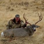 Hunter with large deer trophy.