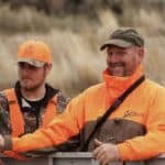 Two hunters in orange attire.